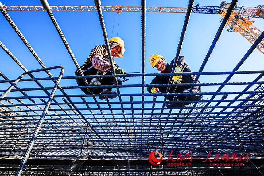 來自四川涼山的彝族夫婦阿西阿古、阿的阿呷正在進(jìn)行鋼筋綁扎作業(yè)。高空作業(yè)雖累,但兩人做得很認(rèn)真。