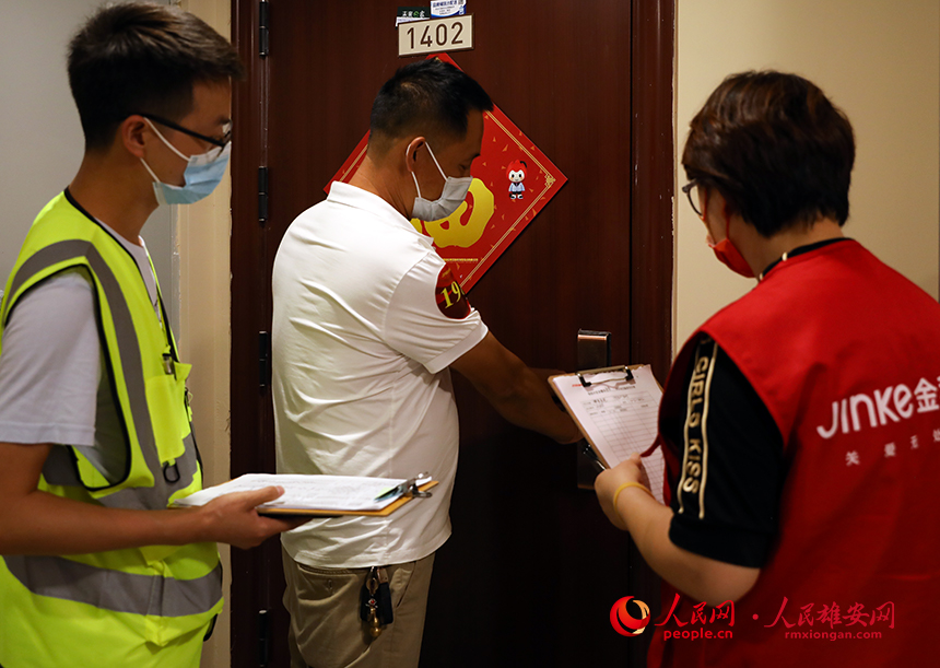 回遷群眾在驗(yàn)房師的陪同下打開(kāi)新家大門。人民網(wǎng)?宋燁文攝