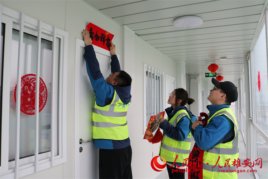 圖為建設者們正在貼對聯。中建三局集團北京有限公司供圖