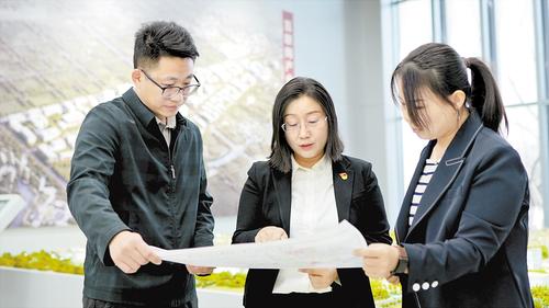 2024年2月，在北京非首都功能疏解中心，夏雨（中）與同事探討項目規劃。受訪者供圖