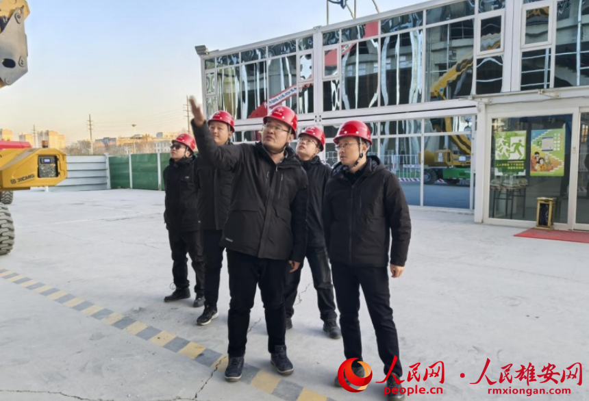 朱懷宇（右一）在雄州站施工現(xiàn)場。人民網(wǎng)記者 唐心怡攝