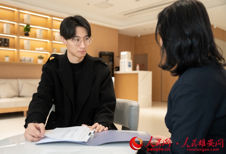 崔鵬飛正在和同事溝通酒店運營情況。人民網(wǎng)記者 楊文娟攝