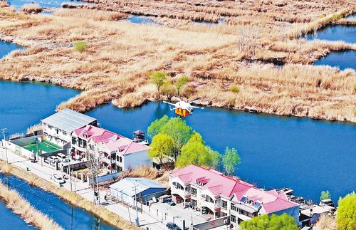 3月21日，中國郵政無人機飛越白洋淀上空，為安新縣圈頭鄉居民配送包裹。 本報記者 張 昊攝