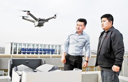 5月7日，雄安新區(qū)中關(guān)村科技園，巡飛智能（雄安）科技有限公司董事長黃玉強（左）與技術(shù)人員一起對無人機進行巡航作業(yè)檢測。 本報記者劉光昱攝