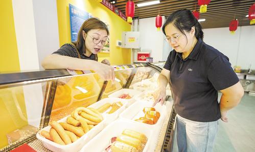 7月11日，位于雄安·老字號商業街的中華老字號天津“迎賓”牌肉制品門店內，顧客正在挑選火腿。本報見習記者 李暢攝