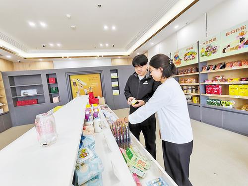 10月11日，雄安保稅商品直購體驗店工作人員（左）向消費者介紹保稅商品。 本報見習記者 康曉博攝